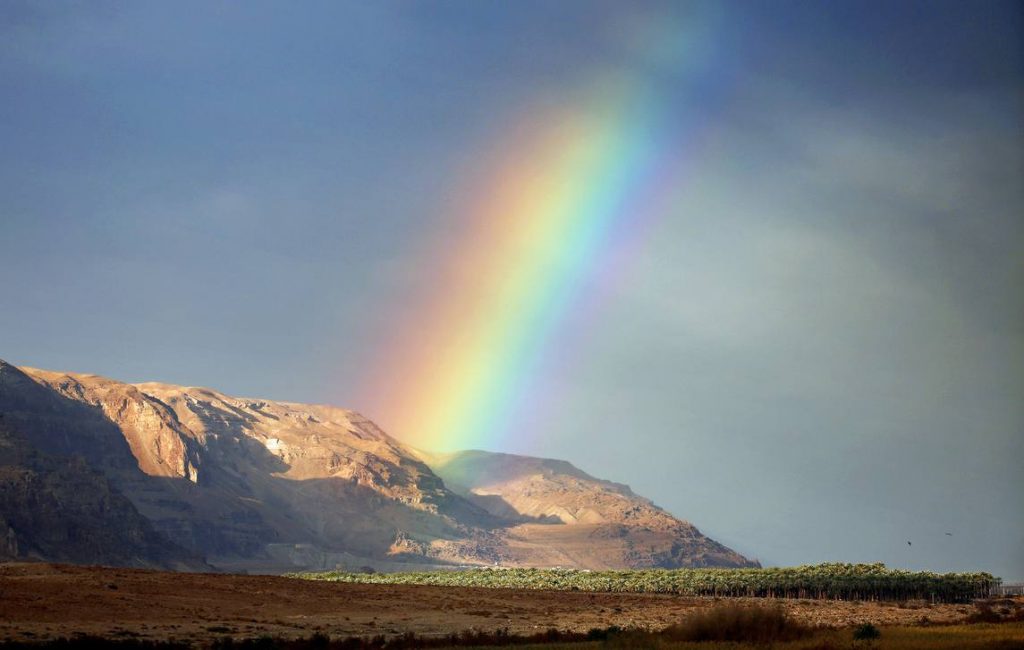 A rainbow rises from the mountains near the Dead Sea.